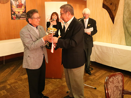 第五回 伏見博明殿下杯チャリティゴルフ大会表彰式、伏見杯を手にする優勝者と称える伏見殿下