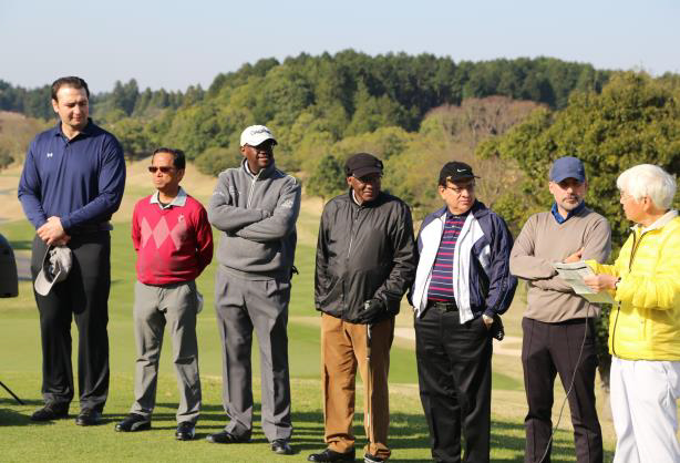 来賓の鳴門親方（元大関琴欧洲）とDCGCメンバー大使の方々をご紹介する小松敏彦競技委員長